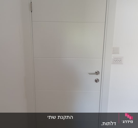 דלת לבנה עם ידית מתכת כסופה